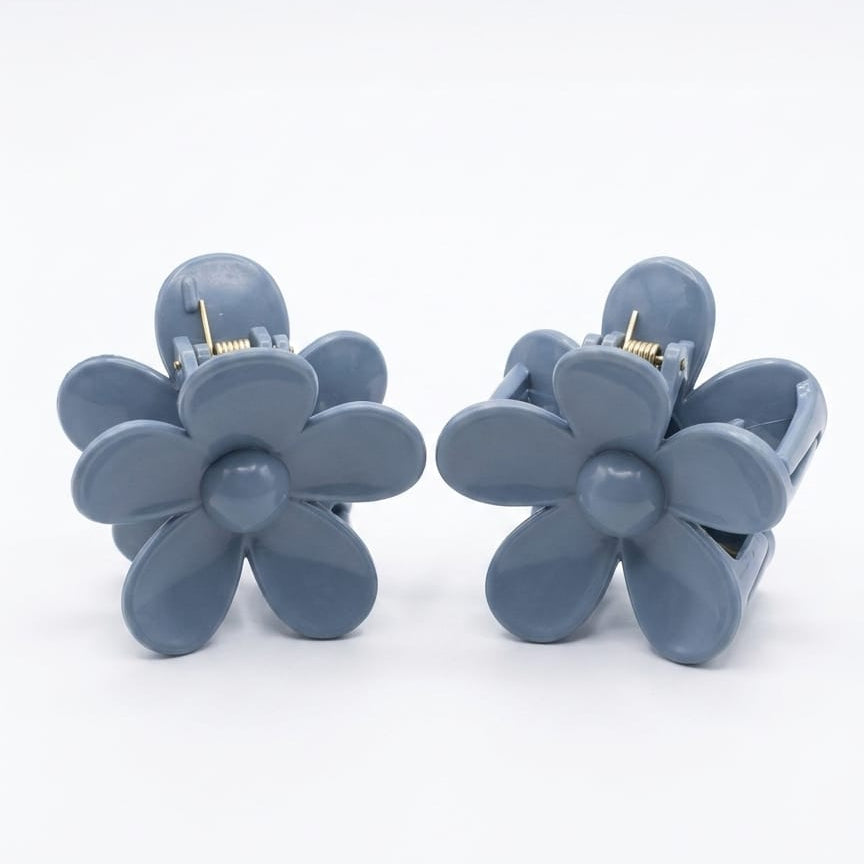 Pair of blue flower-shaped hair clips on a white background