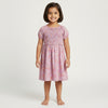 Young girl wearing a pink floral dress on a white background