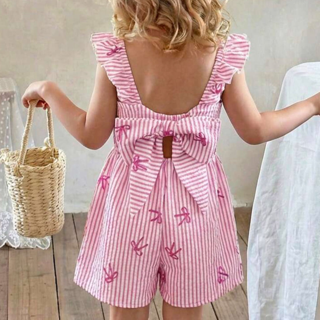 Child wearing a pink and white striped romper with butterfly designs, holding a woven basket.