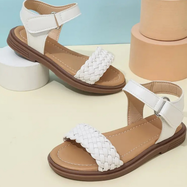 White sandals with braided straps on a light background