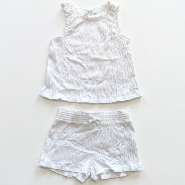 White ruffled top and shorts set on a light beige background