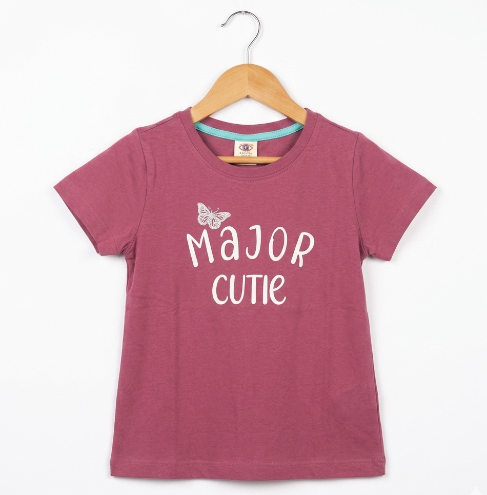 Pink t-shirt with 'Major Cutie' text on a wooden hanger against a white background