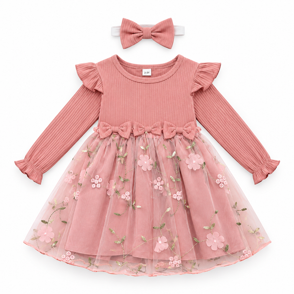A toddler girl's long-sleeve dress in dusty pink, featuring a ribbed knit bodice, ruffled sleeves, a matching pink bow at the waist, and a layered tulle skirt with embroidered pink flowers and green leaves. A matching pink bow headband is displayed above the dress on a white background.
