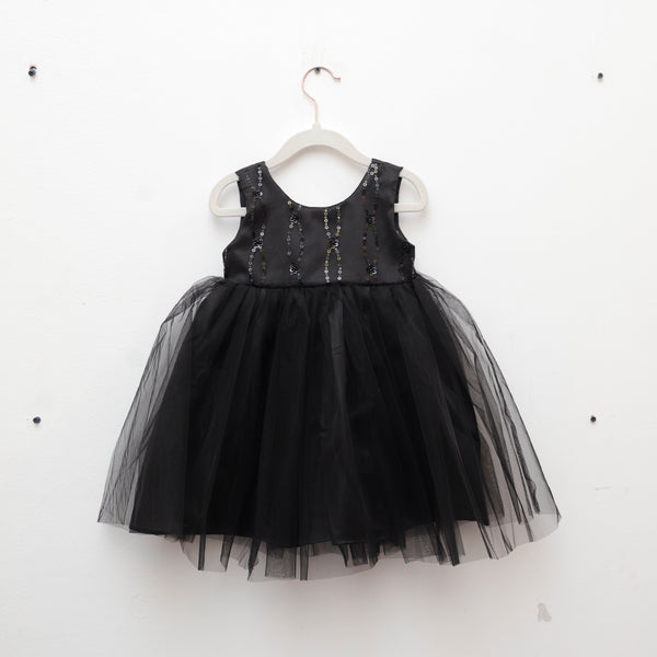 Black dress with sequin top on a white hanger against a white background