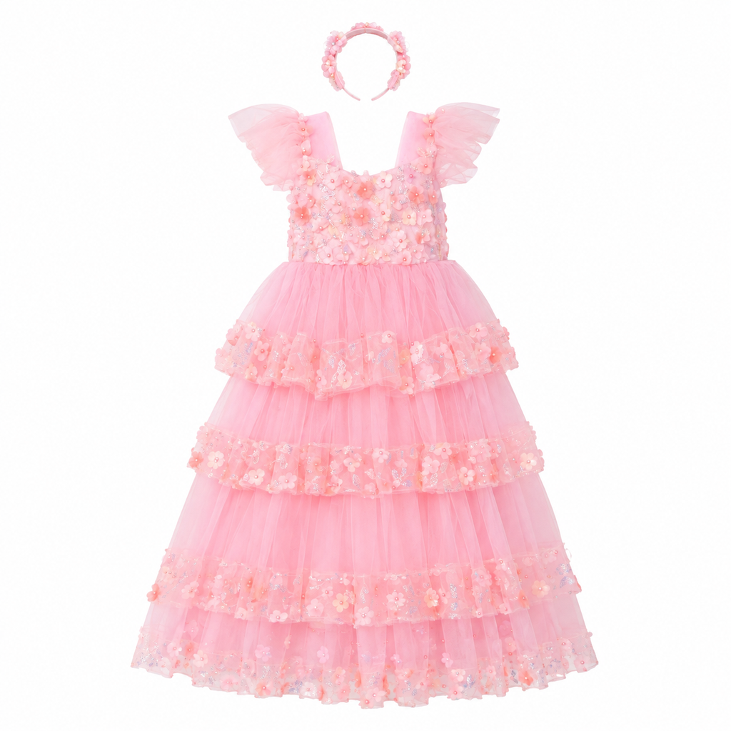 A pink girl's party dress with a matching floral headband, featuring a tiered tulle skirt and ruffled cap sleeves on a solid white background.