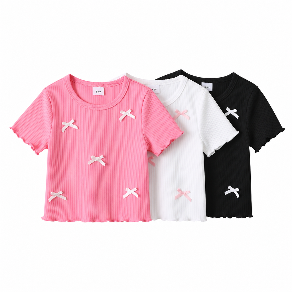 Three t-shirts in pink, white, and black with bow designs on a white background