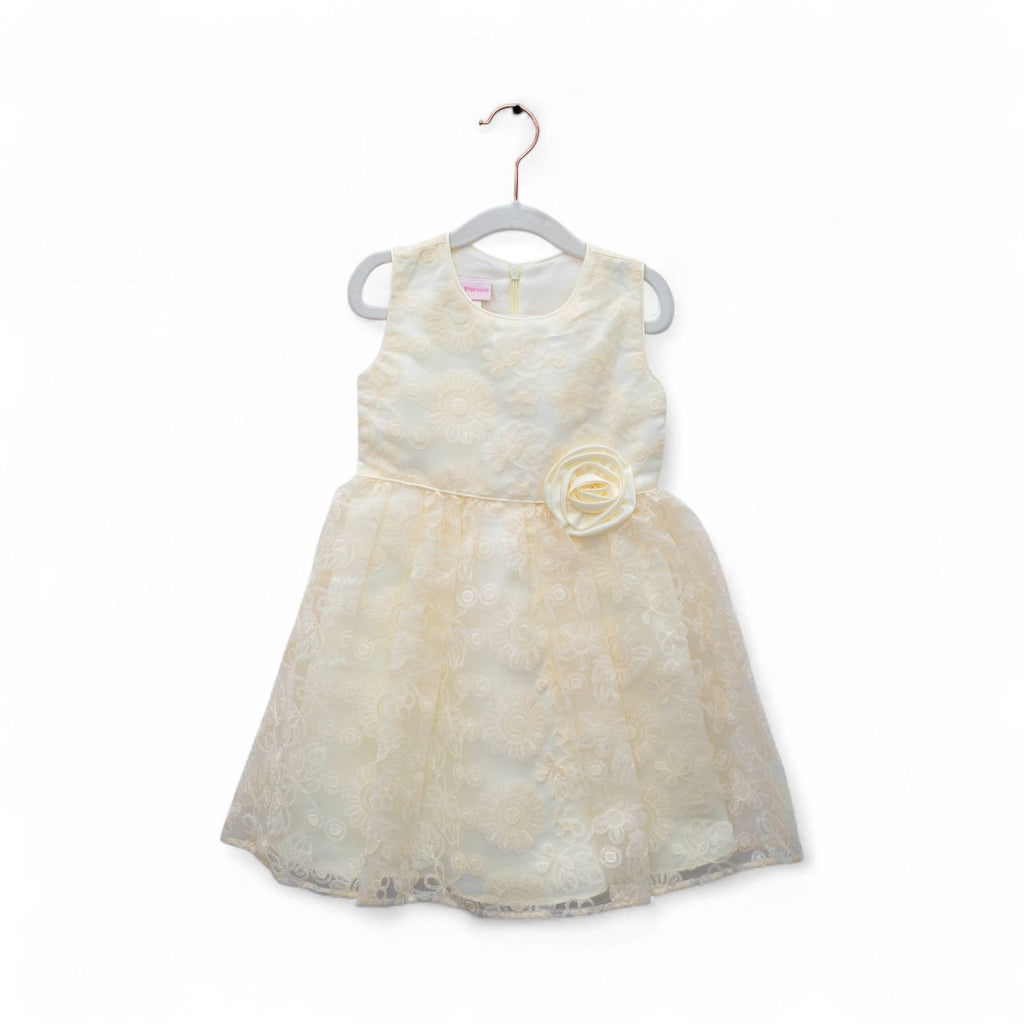 White dress with a floral detail on a hanger against a white background