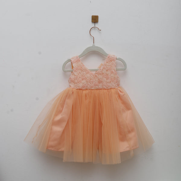 Peach-colored dress with lace detail on a white background