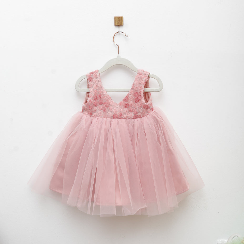 Pink tulle dress with lace details on a white background