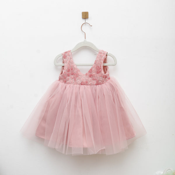 Pink tulle dress with lace details on a white background