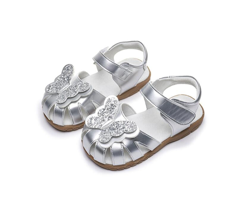 Silver children's sandals with butterfly designs on a white background