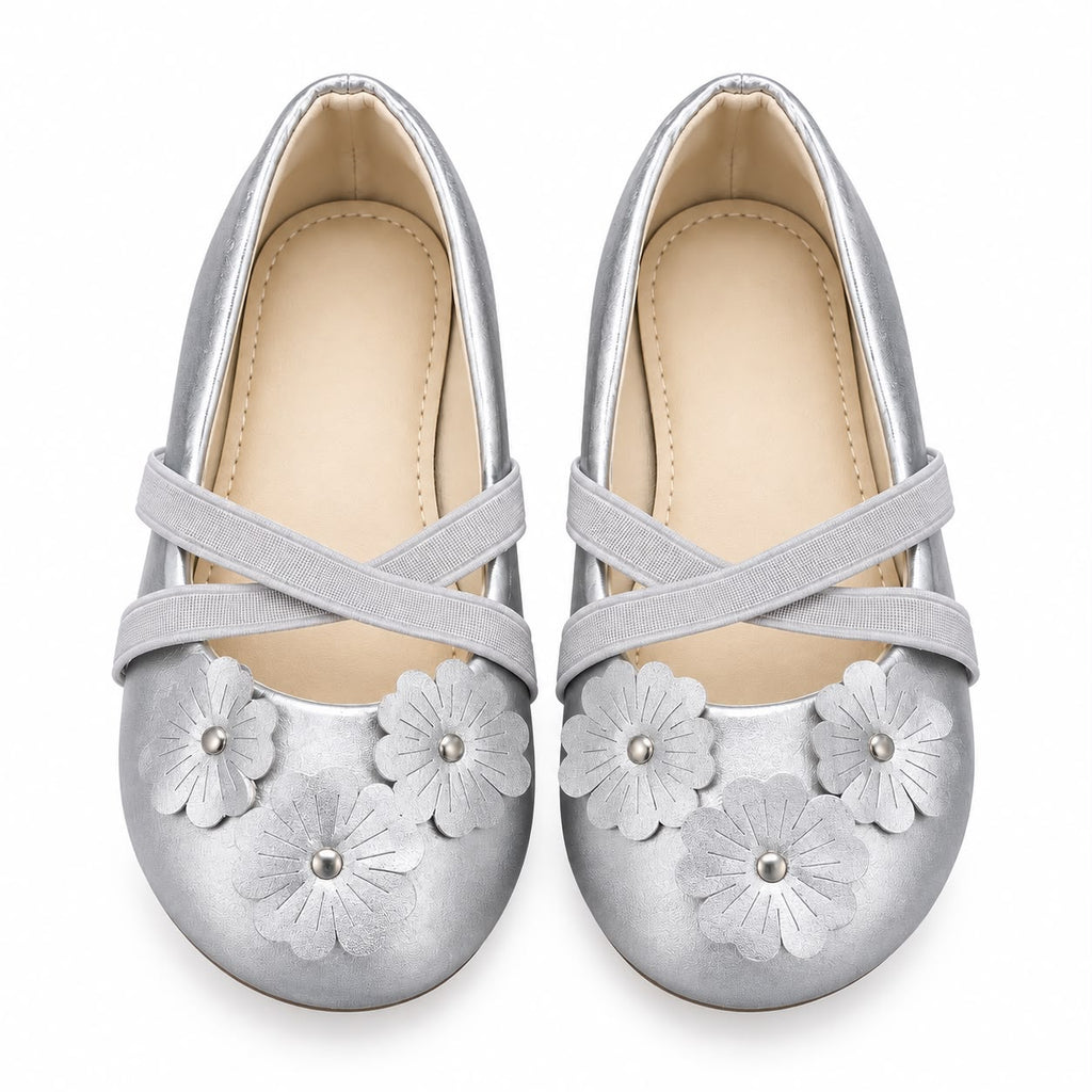 A pair of metallic silver flat shoes for girls, featuring decorative faux leather flower appliqués on the toes and crisscross elastic straps across the instep, shown against a plain white background.