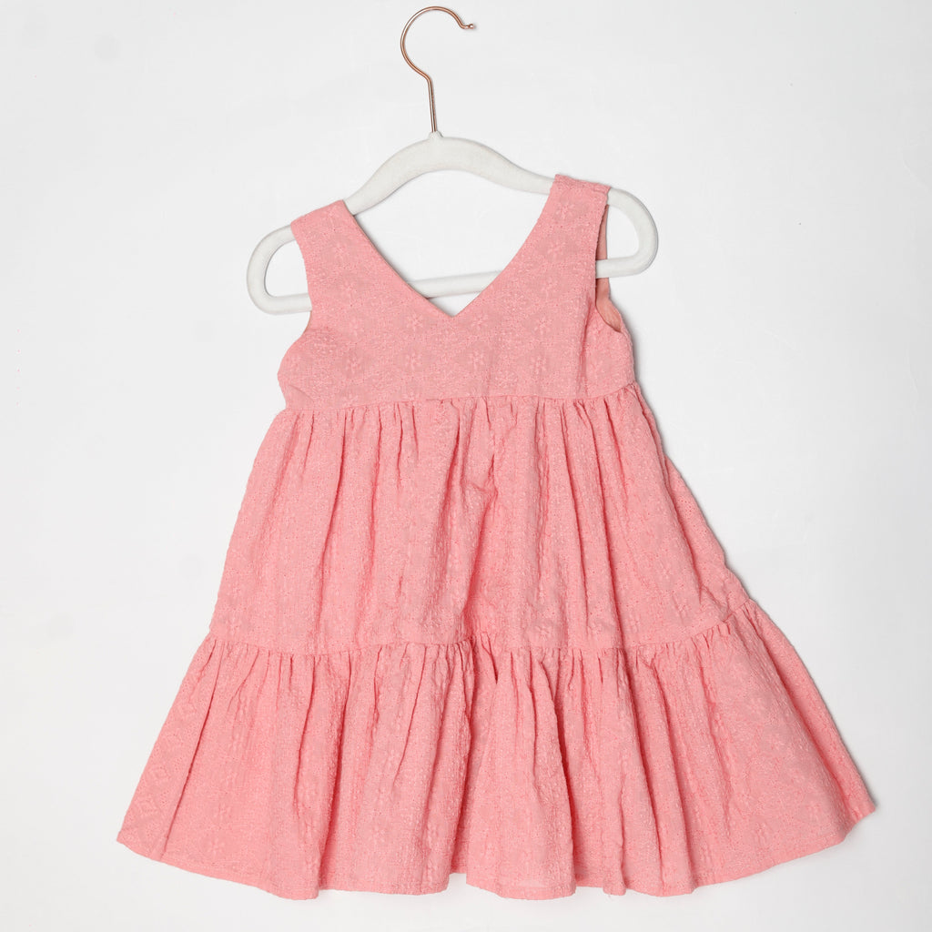 Pink dress on a white hanger against a white background