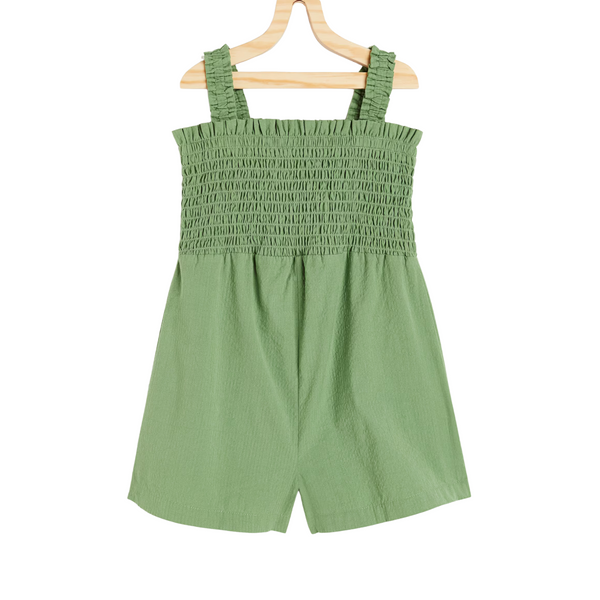 Green smocked romper on a wooden hanger against a white background