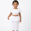 Young girl wearing a white outfit with ruffled details on a white background