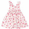A sleeveless white dress with a pink and red floral print, featuring ruffled shoulder straps, a smocked waist, and a tie detail at the neckline, shown against a plain white background.