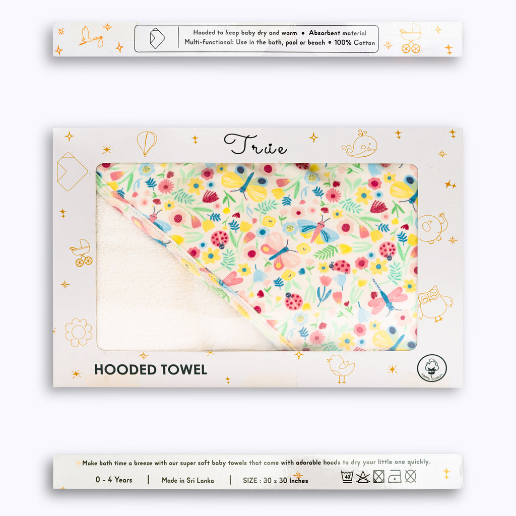 Packaged hooded towel with a floral pattern, displayed in its packaging.
