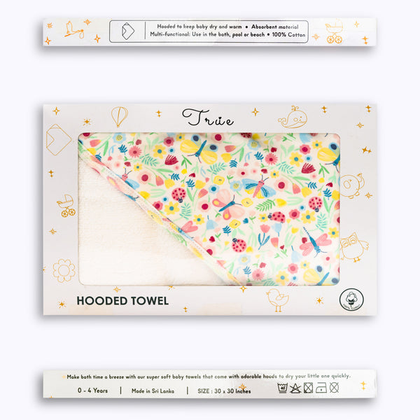 Packaged hooded towel with a floral pattern, displayed in its packaging.