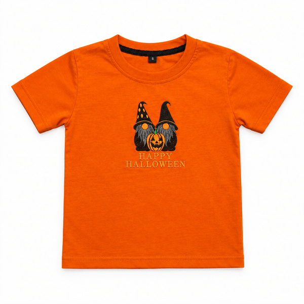 A bright orange short-sleeve kids' t-shirt with a Halloween graphic of two gnome faces behind a jack-o'-lantern and the text 'HAPPY HALLOWEEN' printed on the chest.