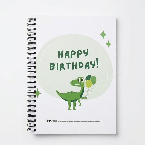 Notebook with a dinosaur holding balloons and 'Happy Birthday!' text on the cover.