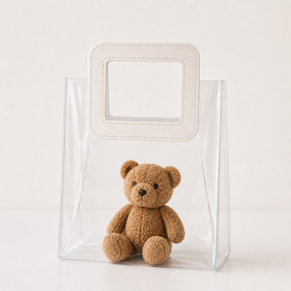Clear plastic bag with a small brown teddy bear inside on a white background