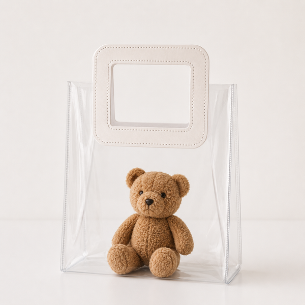 Clear plastic bag with a small brown teddy bear inside on a white background