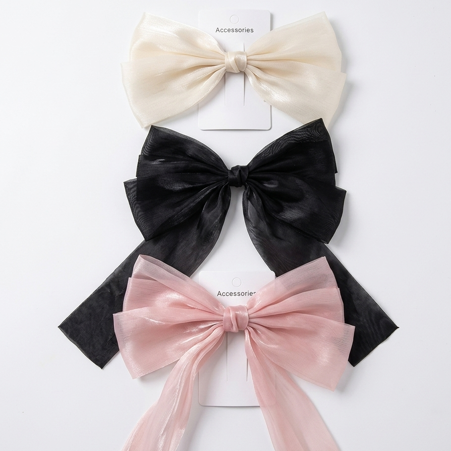 Three large decorative bows in beige, black, and pink on a white background.