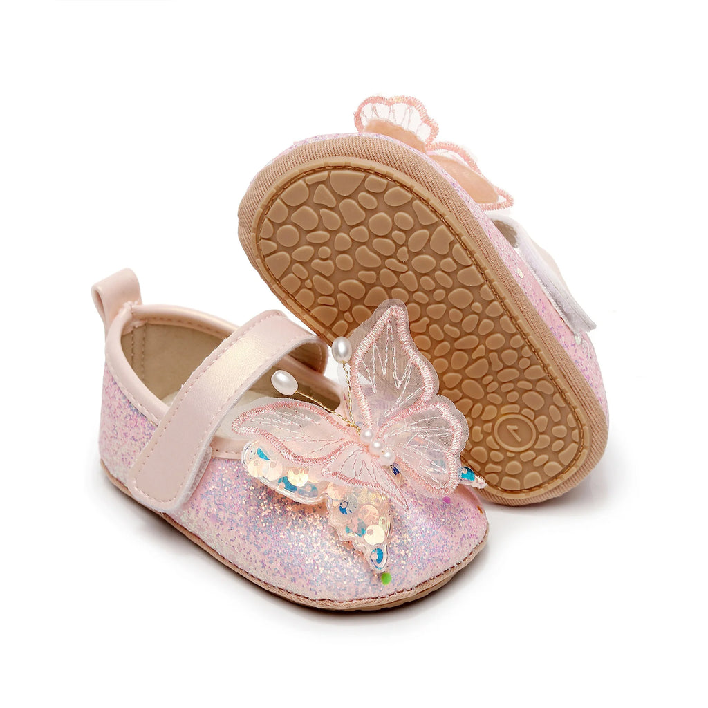 Pink glittery baby shoes with butterfly design on a white background