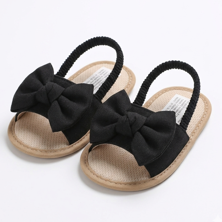 Black sandals with large bows on a white background