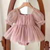 Pink baby dress with sheer sleeves on a wooden hanger against a neutral background