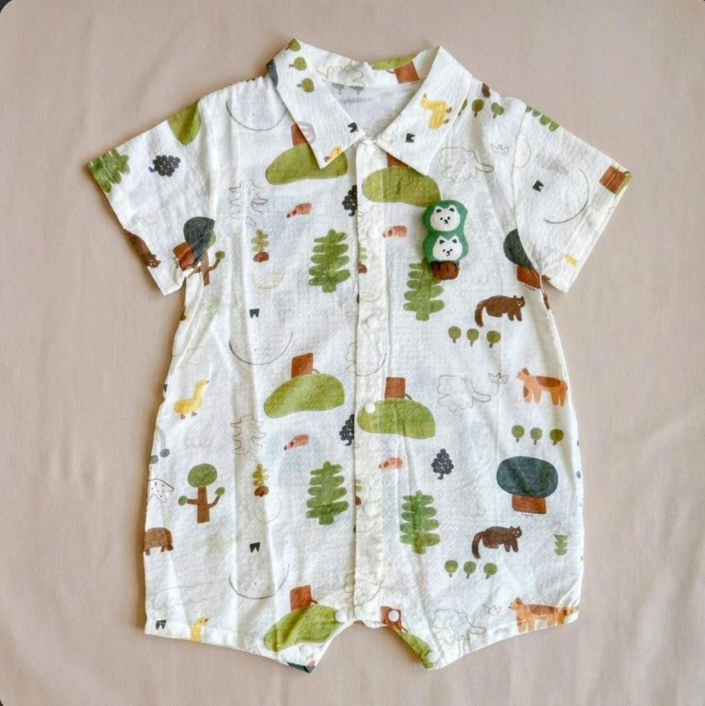 Baby romper with animal and nature pattern on a beige surface