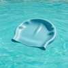 Blue swim cap floating on clear blue water