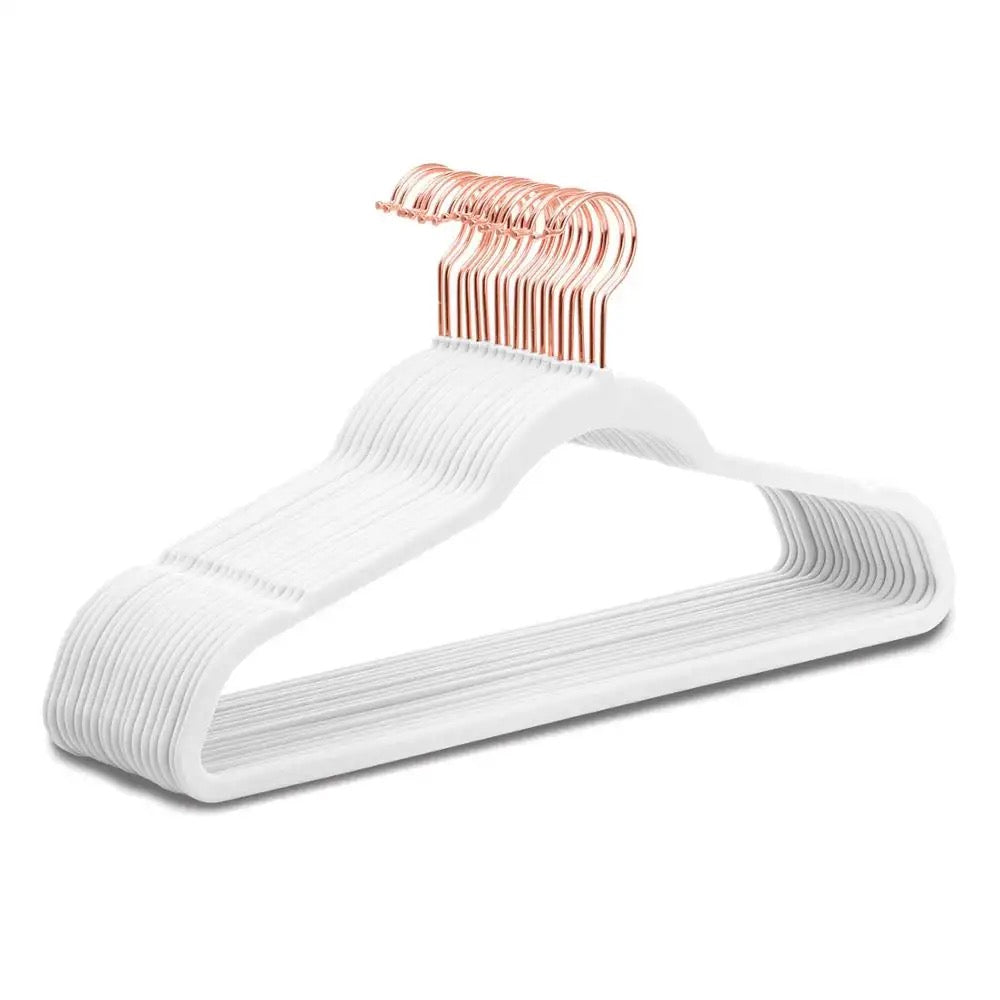 A set of white velvet hangers with rose gold hooks, designed for children's clothing.