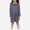 A girl wearing a navy floral print dress with short sleeves and a flowing skirt.