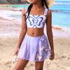  a lilac-colored bikini swim suit with a butterfly pattern, paired with a matching skirt with a butterfly design.