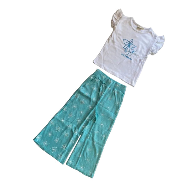 Children's outfit with white top and teal pants on a light gray background