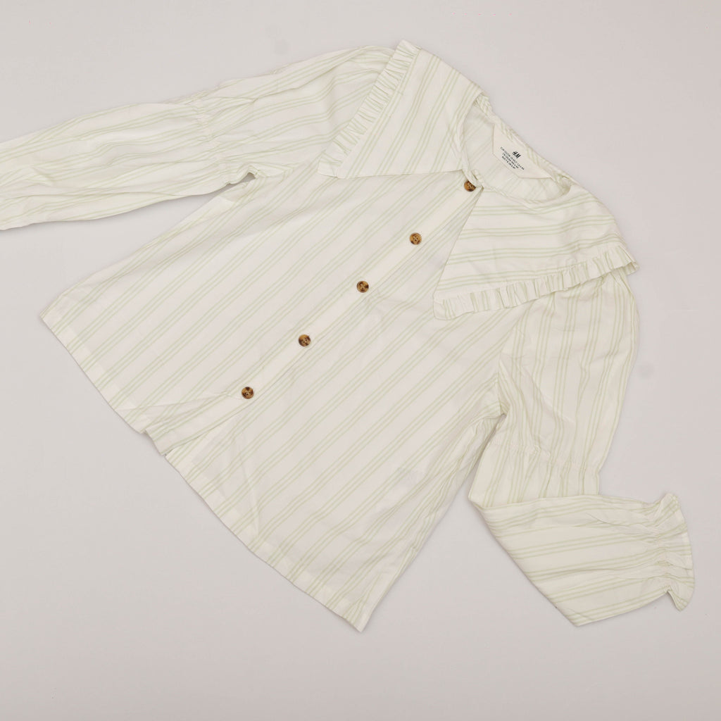 White ribbed knit cardigan with brown buttons on a light gray background