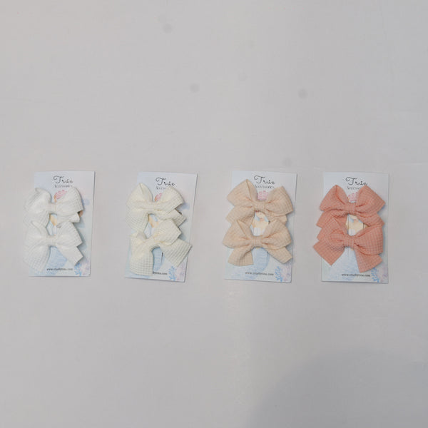 Four hair bows on cards with 'Tula' branding against a light gray background