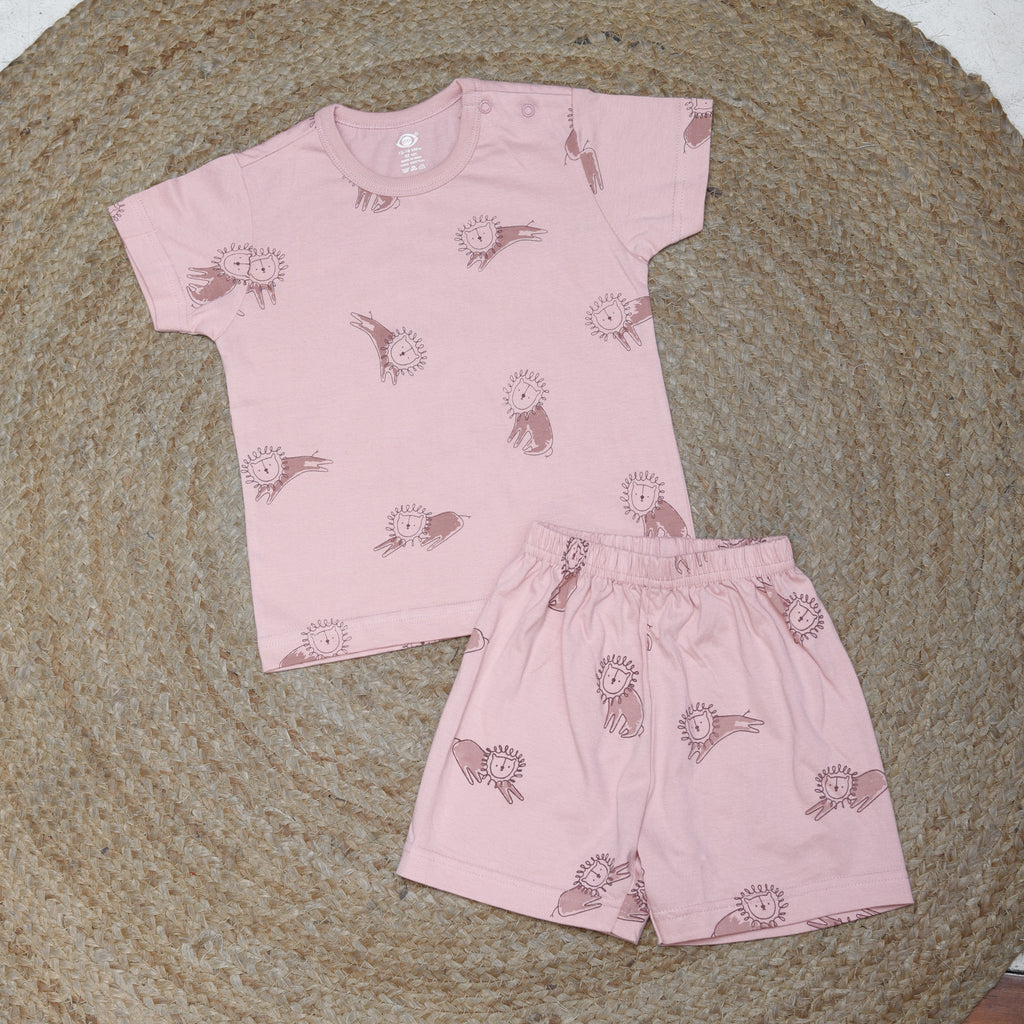 Pink children's outfit with animal pattern on a textured surface