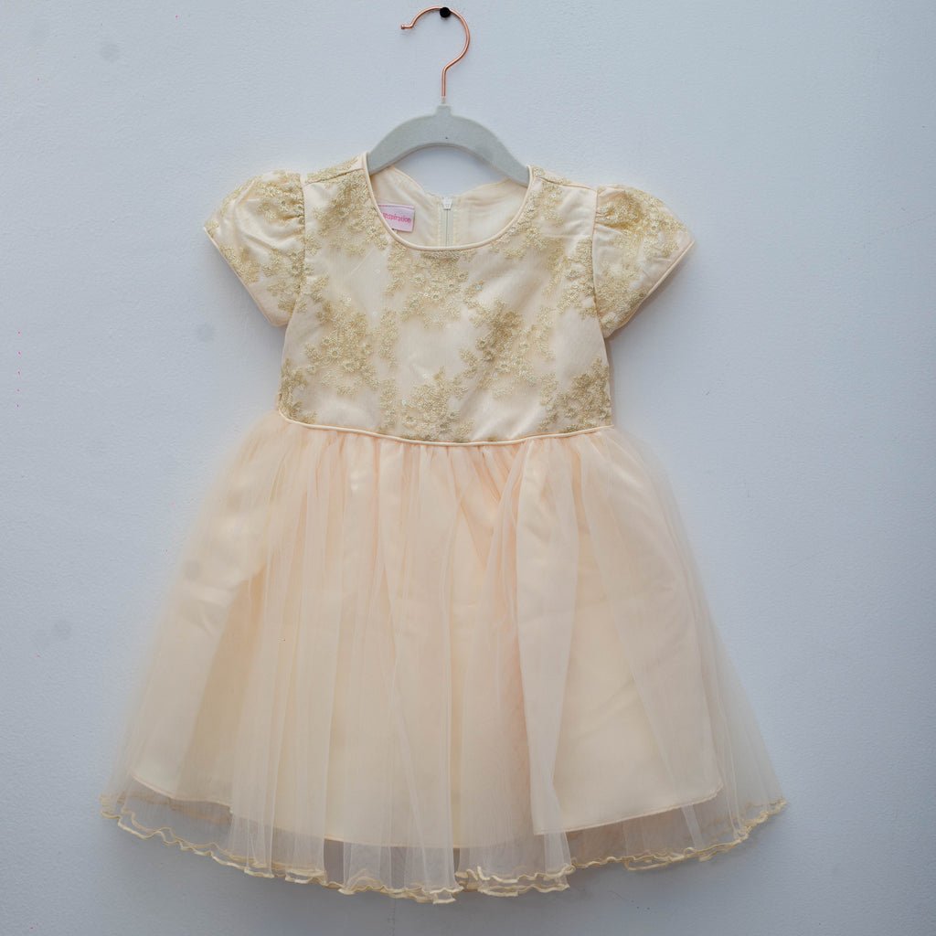 Beige dress on a hanger against a light gray background