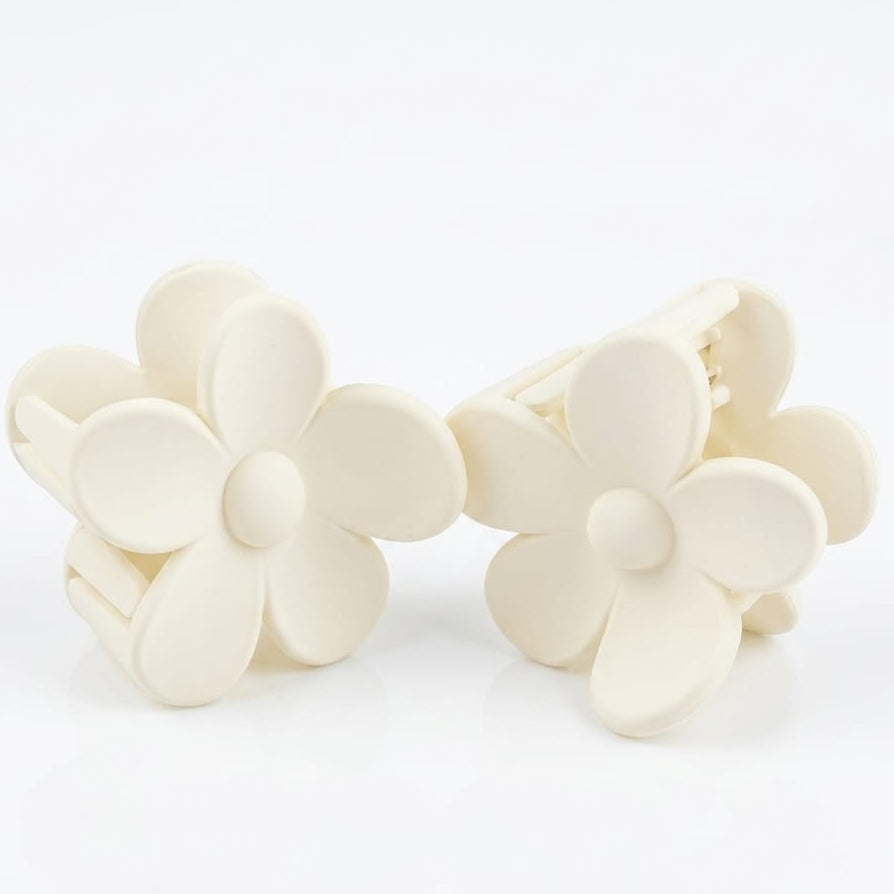 Set of white flower-shaped hair clips on a white background