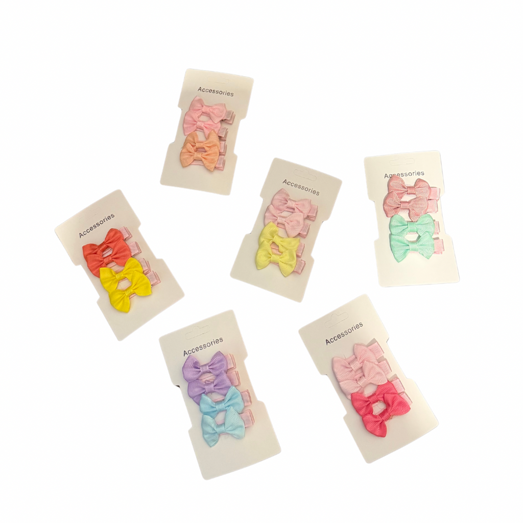 Set of colorful girls hair clips on branded cards against a white background