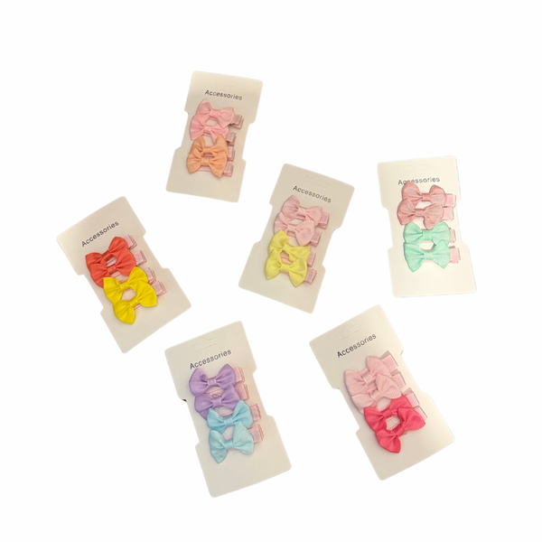 Set of colorful girls hair clips on branded cards against a white background