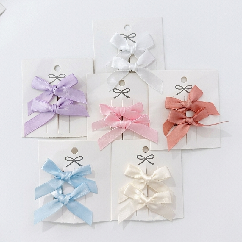 Set of colorful hair bows on white cards with a white background