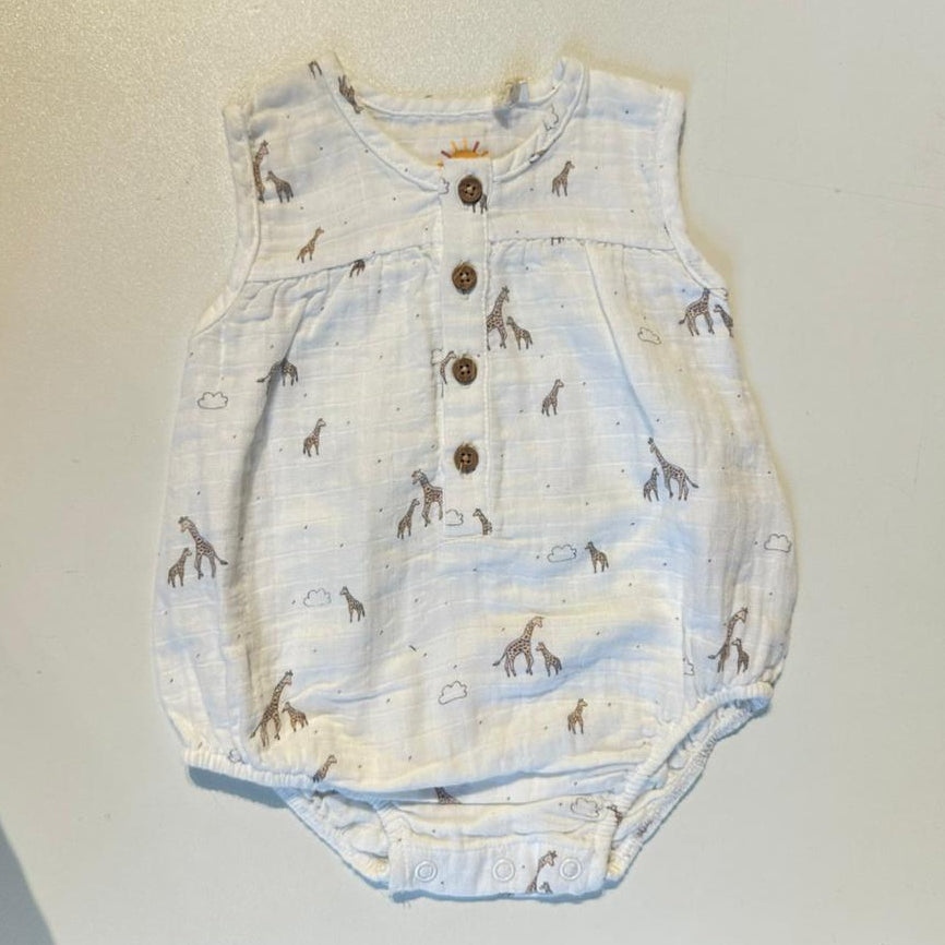 Baby romper with giraffe pattern on a plain background