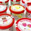 Multiple containers of Simply Play scented clay, with various fruit and candy themed labels such as strawberry, lime, raspberry, and cherry.