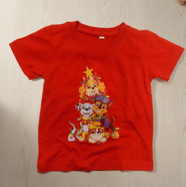 Red t-shirt with cartoon characters on a wooden surface