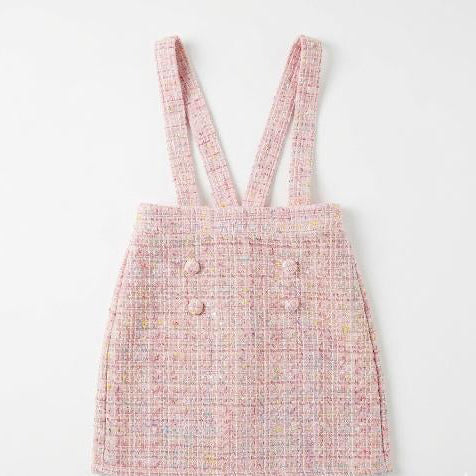 Pink tweed dress with suspenders on a white background