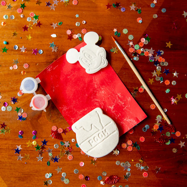 Red paper with white bear-shaped stamps on a wooden surface with colorful confetti.