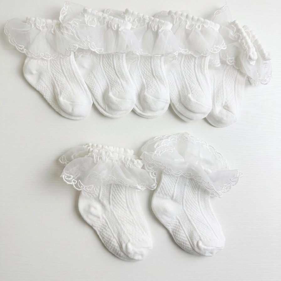 Set of white lace-trimmed socks on a light gray background